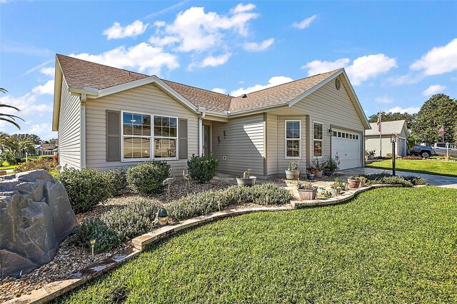 single story home with a garage and a front lawn