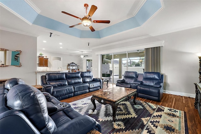 living room featuring crown molding, dark hardwood / wood-style floors, and a tray ceiling