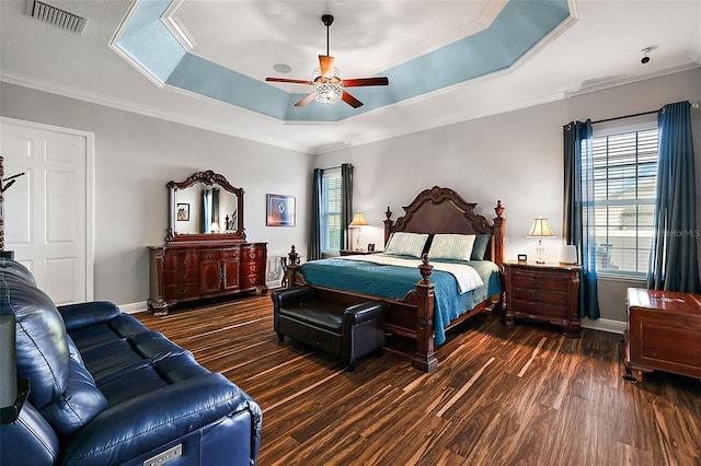 bedroom with dark hardwood / wood-style flooring, crown molding, a raised ceiling, and ceiling fan