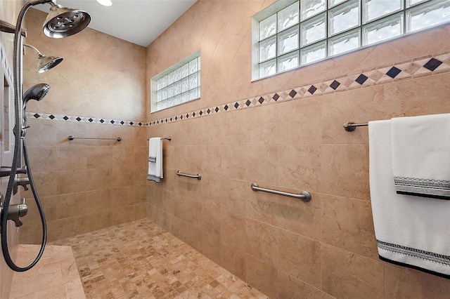 bathroom with a healthy amount of sunlight and tiled shower