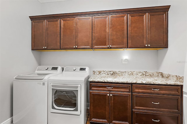 clothes washing area with cabinets and separate washer and dryer