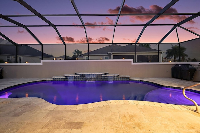 pool at dusk with area for grilling, a hot tub, pool water feature, a patio, and glass enclosure