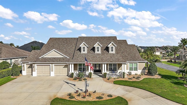 view of front of property with a front yard, a porch, and a garage