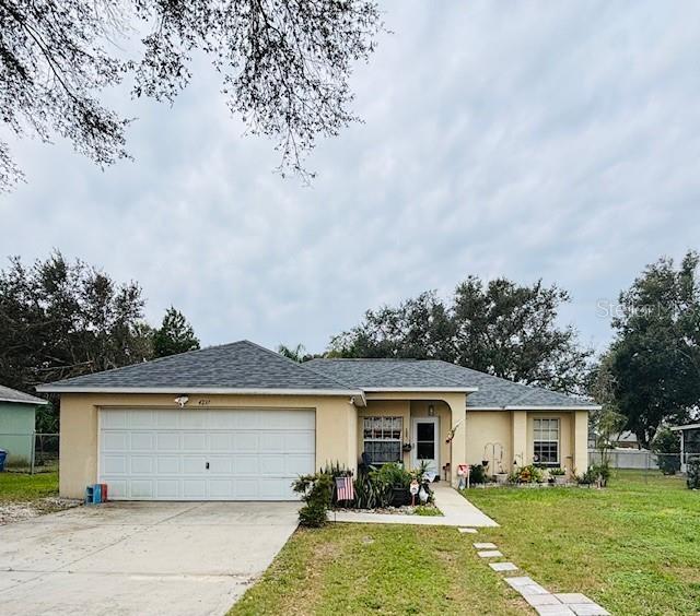 single story home with a garage and a front lawn