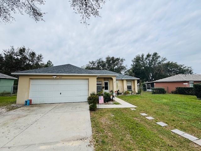 ranch-style home with a front lawn and a garage