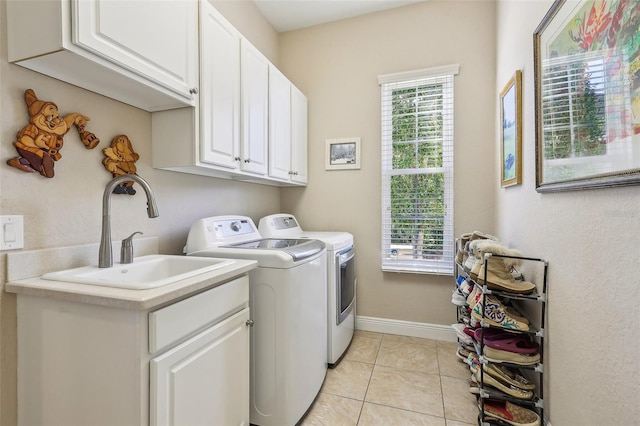 laundry area with sink, light tile patterned flooring, cabinets, and washer and clothes dryer