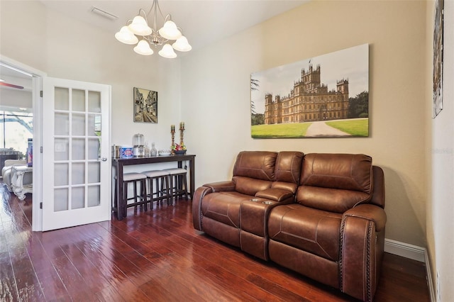 living room with lofted ceiling, a notable chandelier, and dark hardwood / wood-style flooring