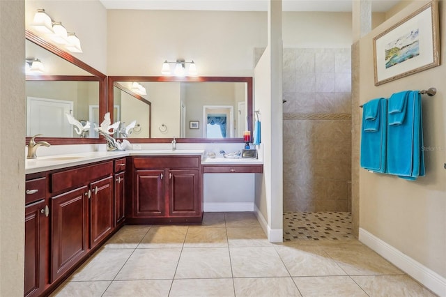 bathroom with vanity, a tile shower, and tile patterned floors