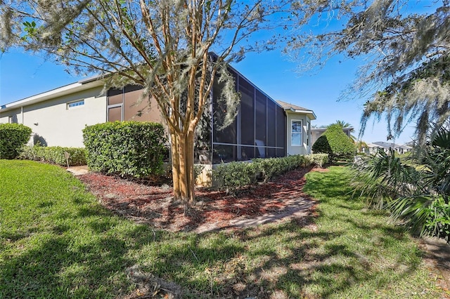 view of side of property featuring a sunroom and a lawn