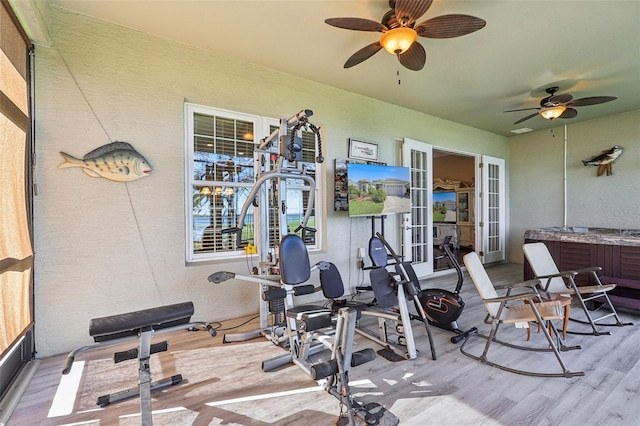 workout area featuring french doors, light hardwood / wood-style floors, and ceiling fan