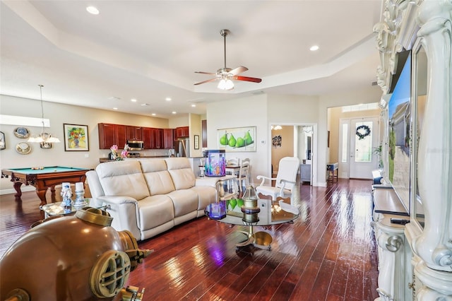 living room with dark wood-type flooring, ceiling fan, a tray ceiling, and billiards