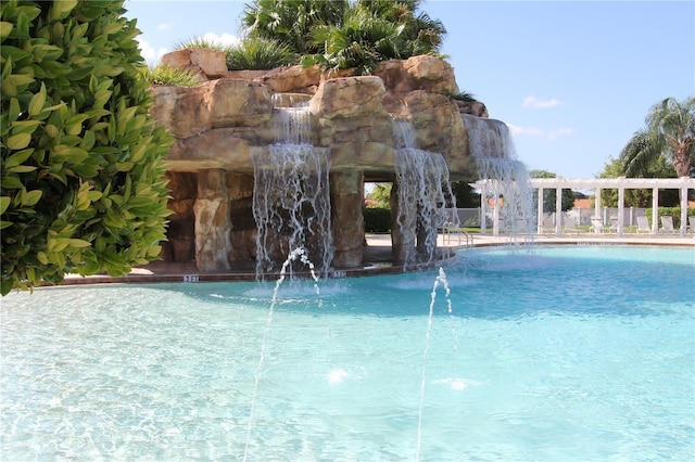 view of swimming pool with pool water feature