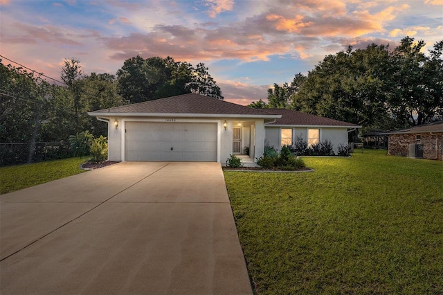 ranch-style home with a garage and a lawn