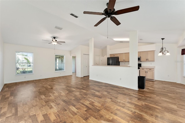 unfurnished living room with ceiling fan with notable chandelier, wood-type flooring, and vaulted ceiling