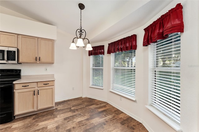 kitchen featuring dark wood-type flooring, vaulted ceiling, black electric range, light brown cabinetry, and decorative light fixtures