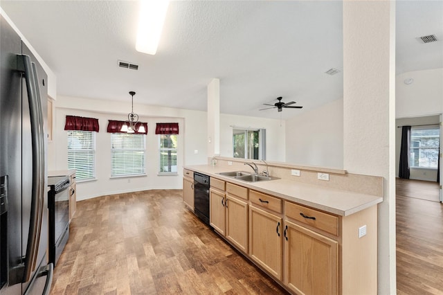 kitchen with ceiling fan with notable chandelier, stainless steel appliances, sink, light brown cabinets, and pendant lighting