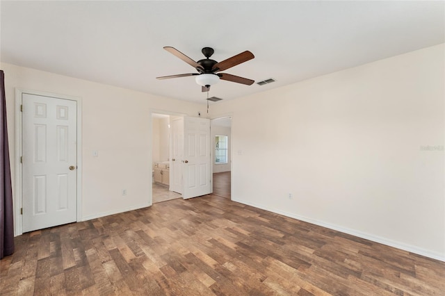 unfurnished bedroom featuring ensuite bathroom, ceiling fan, and dark hardwood / wood-style floors