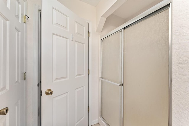 bathroom featuring a shower with shower door