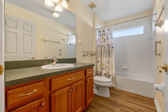 full bathroom featuring vanity, toilet, wood-type flooring, and shower / tub combo with curtain