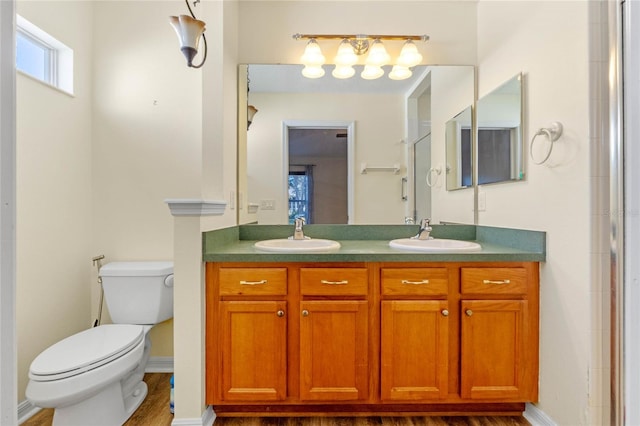 bathroom with vanity, toilet, wood-type flooring, and a shower with shower door