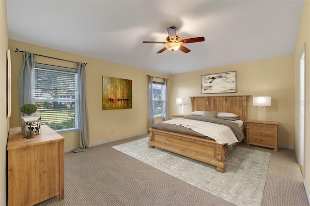 bedroom with multiple windows, light colored carpet, and ceiling fan