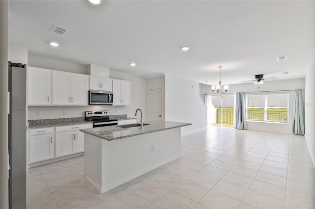 kitchen with a sink, open floor plan, an inviting chandelier, stainless steel appliances, and white cabinetry