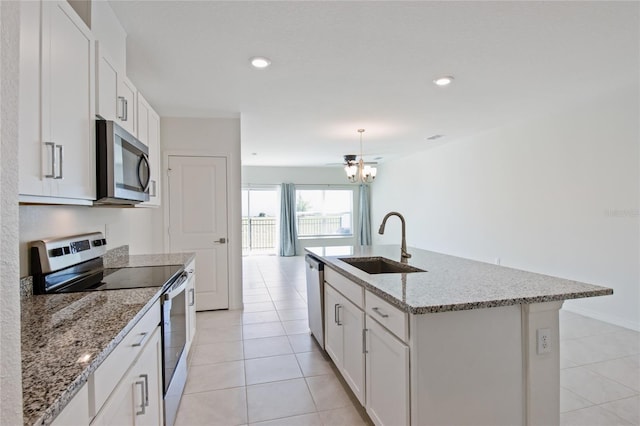 kitchen featuring white cabinets, light tile patterned floors, stainless steel appliances, and a sink