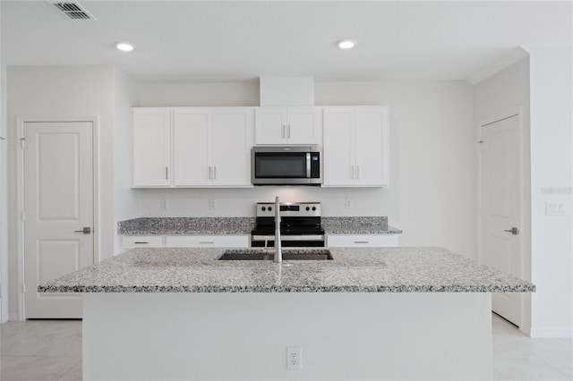 kitchen featuring an island with sink, light stone counters, stainless steel appliances, and white cabinetry