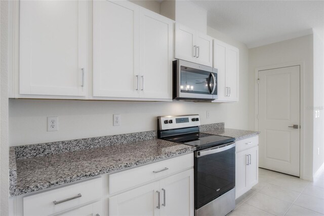 kitchen with white cabinetry, light stone countertops, and stainless steel appliances