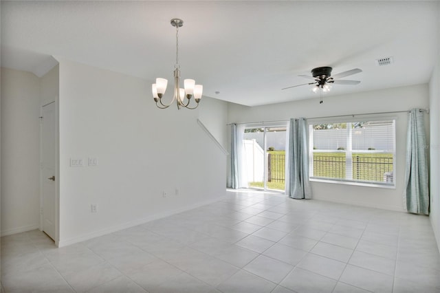 spare room with light tile patterned flooring and ceiling fan with notable chandelier