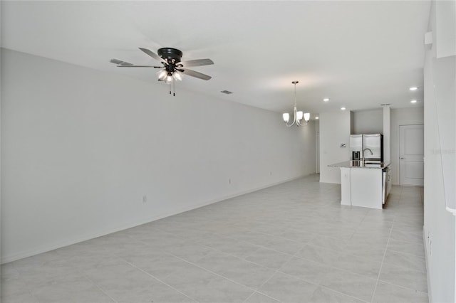 unfurnished room with ceiling fan with notable chandelier and light tile patterned floors