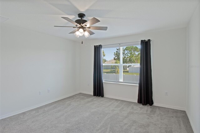 carpeted empty room with baseboards and ceiling fan