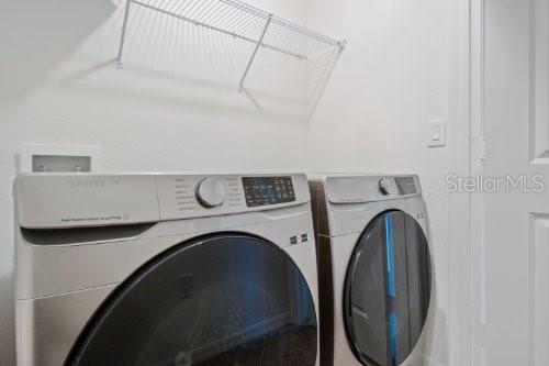 clothes washing area with washer and clothes dryer