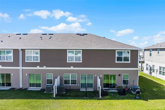 back of house featuring central air condition unit and a lawn