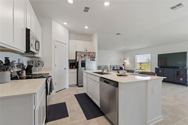 656 Daring Dr, Davenport, FL 33837 - kitchen with visible vents, a sink, white cabinets, open floor plan, and stainless steel appliances