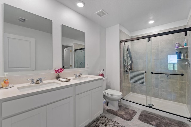 bathroom featuring tile patterned floors, vanity, toilet, and an enclosed shower