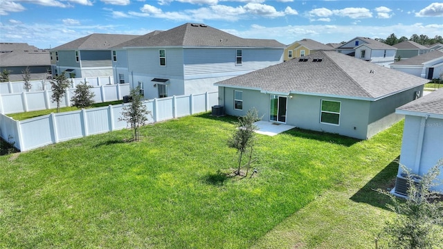 rear view of house with a lawn and cooling unit