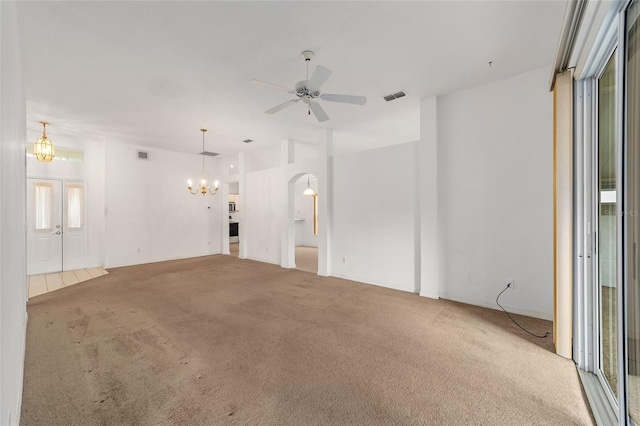 spare room with carpet flooring and ceiling fan with notable chandelier