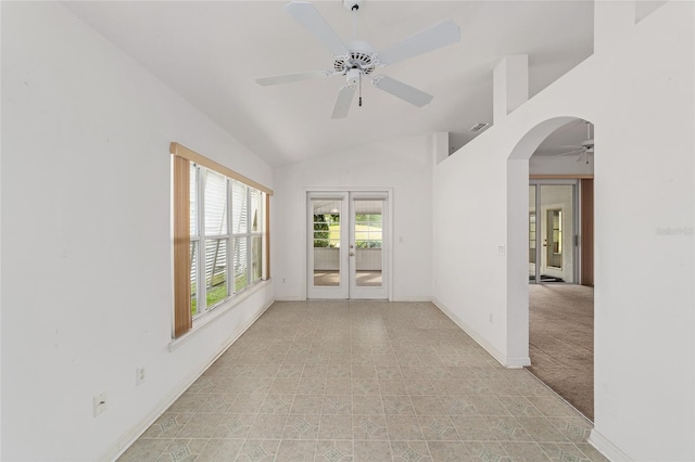 carpeted spare room with french doors, ceiling fan, and vaulted ceiling