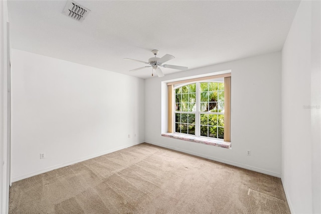 carpeted spare room featuring ceiling fan