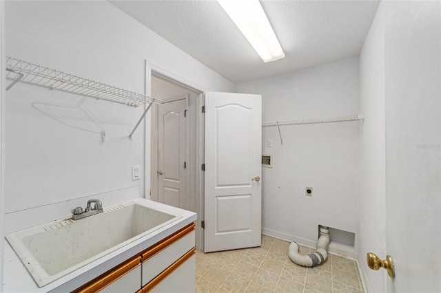 laundry area with sink, electric dryer hookup, and a textured ceiling