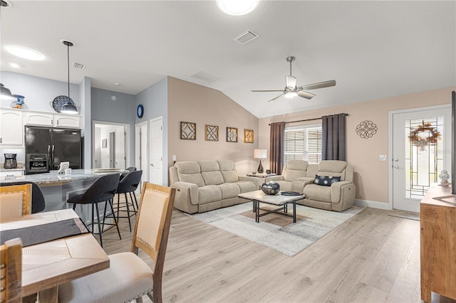 living room featuring ceiling fan, lofted ceiling, and light hardwood / wood-style flooring