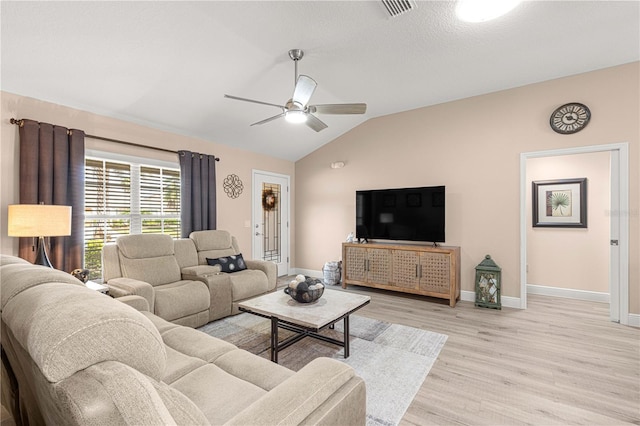 living room with ceiling fan, a textured ceiling, lofted ceiling, and light wood-type flooring