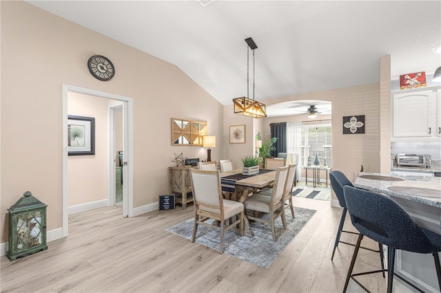 dining area featuring ceiling fan, lofted ceiling, and light hardwood / wood-style flooring