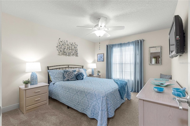 carpeted bedroom featuring ceiling fan and a textured ceiling