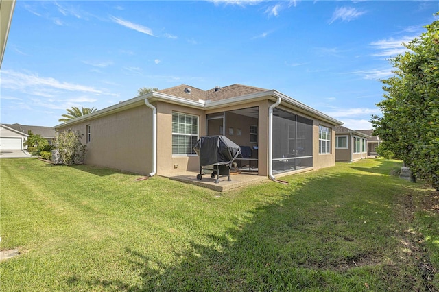 rear view of property with a patio, a lawn, and a sunroom