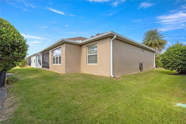 view of side of home with a yard