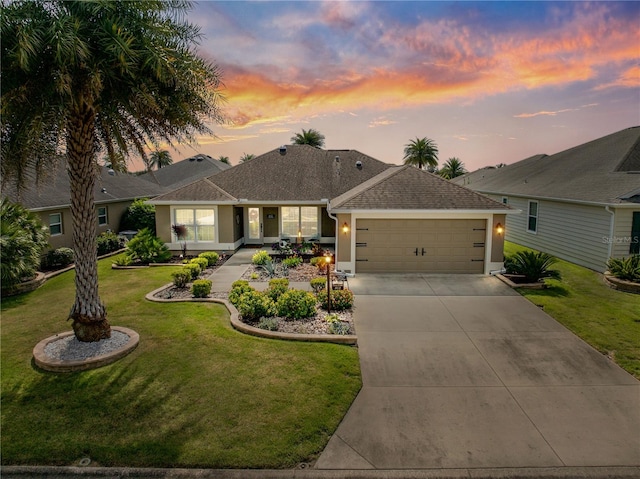 ranch-style home featuring a lawn and a garage