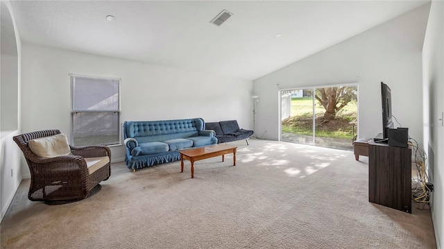 carpeted living room featuring high vaulted ceiling