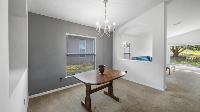 dining space featuring vaulted ceiling, a notable chandelier, and carpet floors